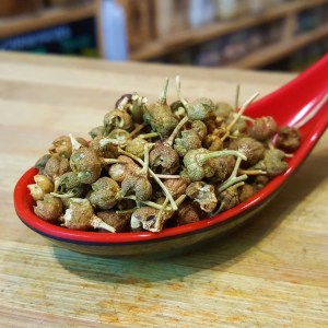 Bayas de color verde con un fino tallo, de tamaño un poco más grande que un grano de pimienta