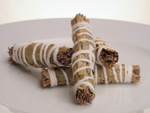 Cuatro atadillos de hierbas con forma de puro atados cada uno con una cuerda