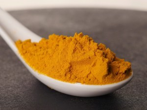 Cuchara llena de cúrcuma molida en la tienda de especias Sally Pepper en Madrid