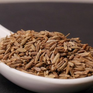 cuchara llena de comino en grano