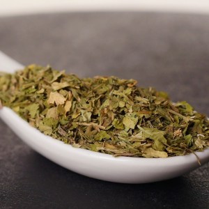Hojas de cilantro secas en una cuchara en la tienda de especias Sally Pepper