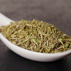 Cuchara de cerámica llena de romero triturado en la tienda de especias y hierbas aromáticas Sally Pepper Spices en Madrid