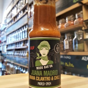 Botella de cristal de salsa brava Juana Madrid con cilantro y chile serrano en la tienda de especias Sally Pepper