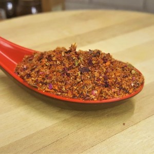 Cuchara llena de la mezcla de especias para hacer Harissa de Rosas en la tienda de especias Sally Pepper en Madrid