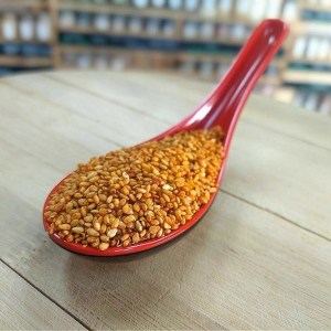 sésamo kimchi de color naranja en cuchara
